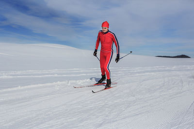 Man skiing on snowcapped mountain against sky