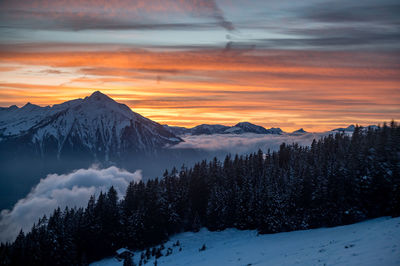 Scenic view of snow covered mountains against sky during sunset