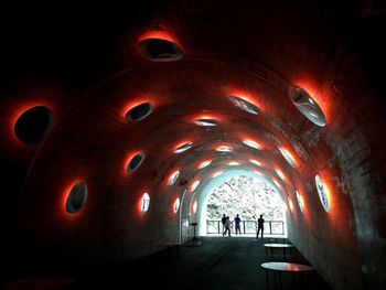 People walking in illuminated tunnel