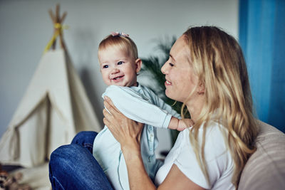 Mom and 1-year-old daughter spend time together at home.