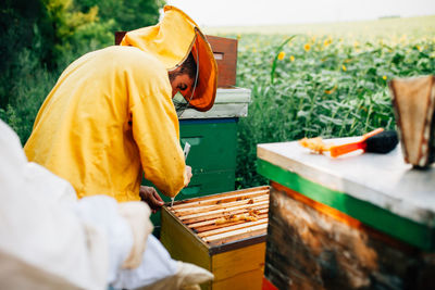 Beekeepers standing by containers