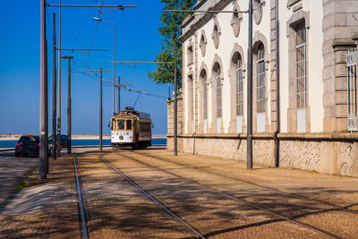 Beautiful old tram and an antique house on a corner of the rua de sobreiras in porto city 