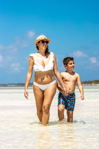 Rear view of shirtless man standing at beach