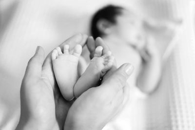 Cropped hands of father holding baby boy legs