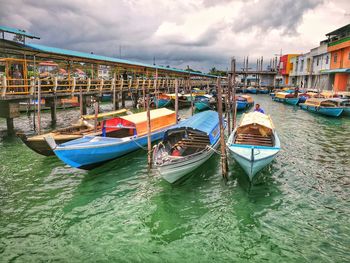 Boats moored in sea against buildings in city