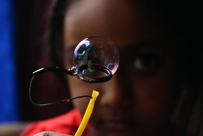Close-up portrait of girl with bubble wand