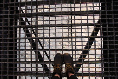 Low section of person standing on footbridge