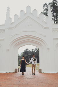 Man and woman standing by historic building