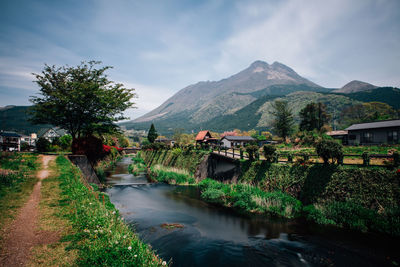 Scenic view of river by mountains against sky