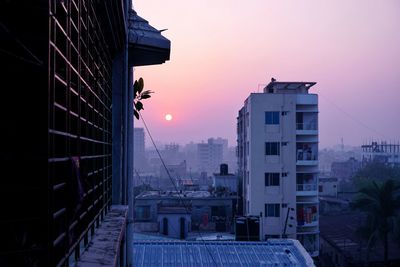 Buildings in city at sunset