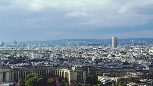 Aerial view of cityscape against cloudy sky