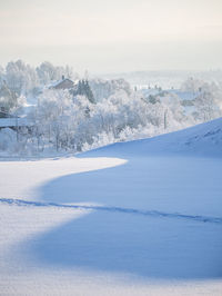 Scenic view of snow covered field against sky