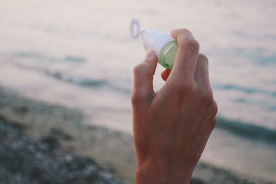 Close-up of hand holding sea shore