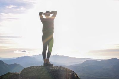 Woman standing on mountain against sky