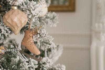 A toy in the form of a skate hangs on a silver christmas tree with a copy space