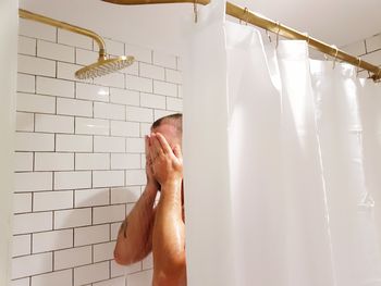 Man taking shower in bathroom