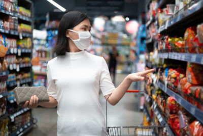 Midsection of woman standing by display at store