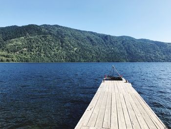 Scenic view of lake and mountains against clear sky