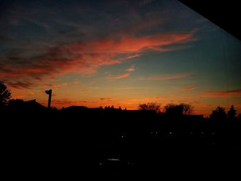 Silhouette landscape against dramatic sky during sunset