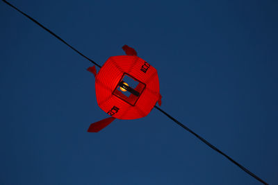 Low angle view of red lantern against blue sky