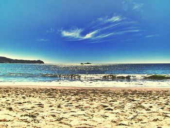 Scenic view of beach against blue sky