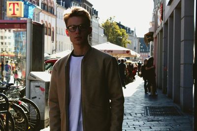 Young man standing on street in city