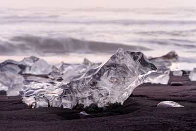 Scenic view of rocks on beach against sky