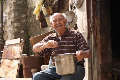 Portrait of man holding metallic container