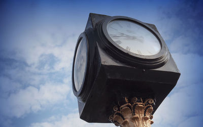 Low angle view of clock against sky