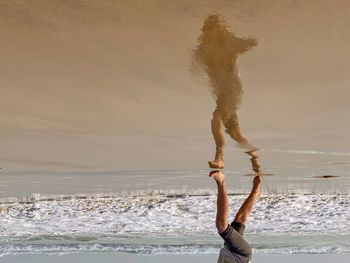 Woman standing at beach against sky