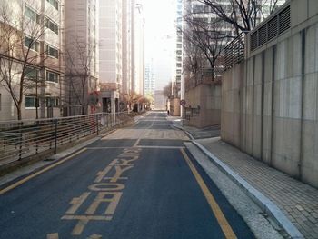 Empty road along buildings