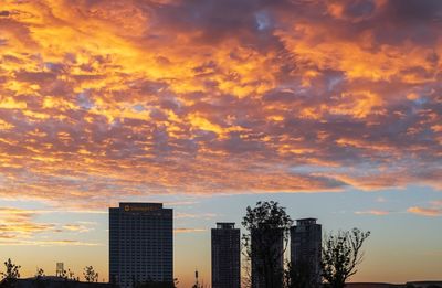 Modern buildings against sky during sunset