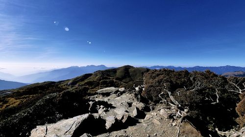 Scenic view of mountains against blue sky