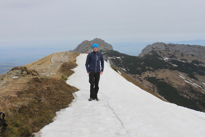 Hiker standing on snow at giewont mountain