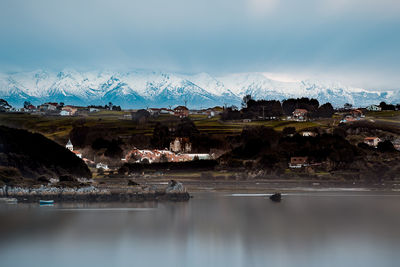 Scenic view of lake by mountains against sky