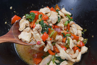 Basil chicken with spicy thai sauce - pad krapao gai cooking in wok