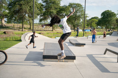 Rear view of people jumping in park