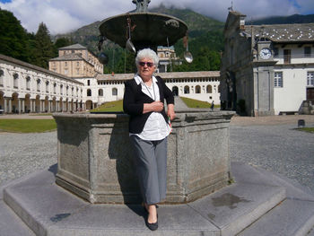 A seventy year old caucasian woman posing near a column