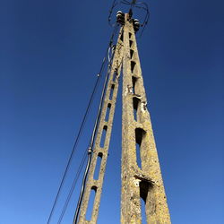 Low angle view of old tower against clear blue sky