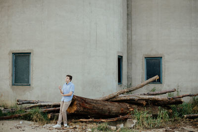 Full length of woman standing against building