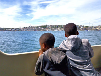 Rear view of people looking at sea against sky