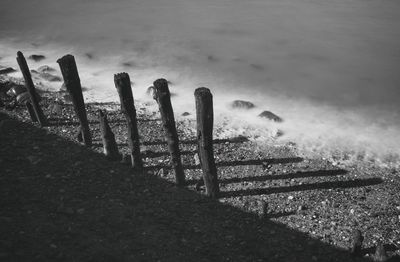 Close-up of fence on beach against sky