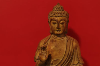 Statue of buddha against red background