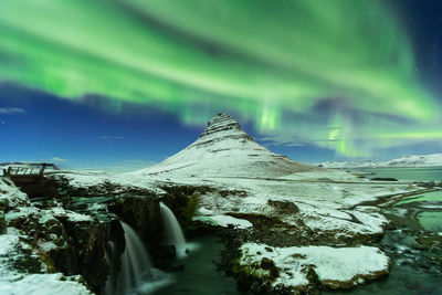 Scenic view of snowcapped mountains against sky at night
