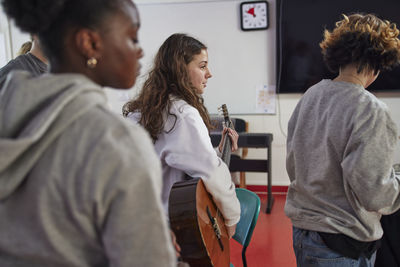 Teenagers attending guitar lesson