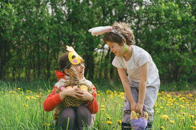 Rear view of mother and daughter standing on field