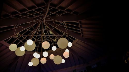 Low angle view of illuminated lights hanging from ceiling