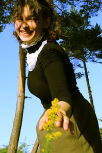 Low angle view of smiling girl against plants