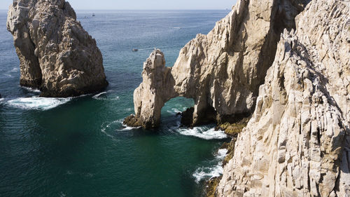 Scenic view of rocks in sea against sky