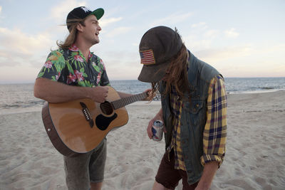 Friends playing music together on a beach